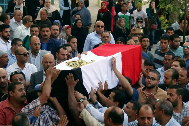 The coffin of police captain Ahmed Fayez, killed in the battle in al-Wahat al-Bahriya, is carried
