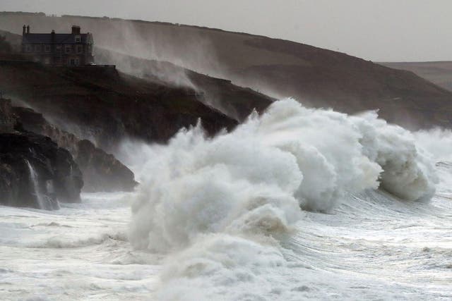 Waves crash into the seafront in Porthleven in Cornwall during Storm Brian