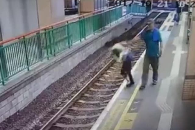CCTV footage shows woman being shoved onto tracks at a Hong Kong railway station