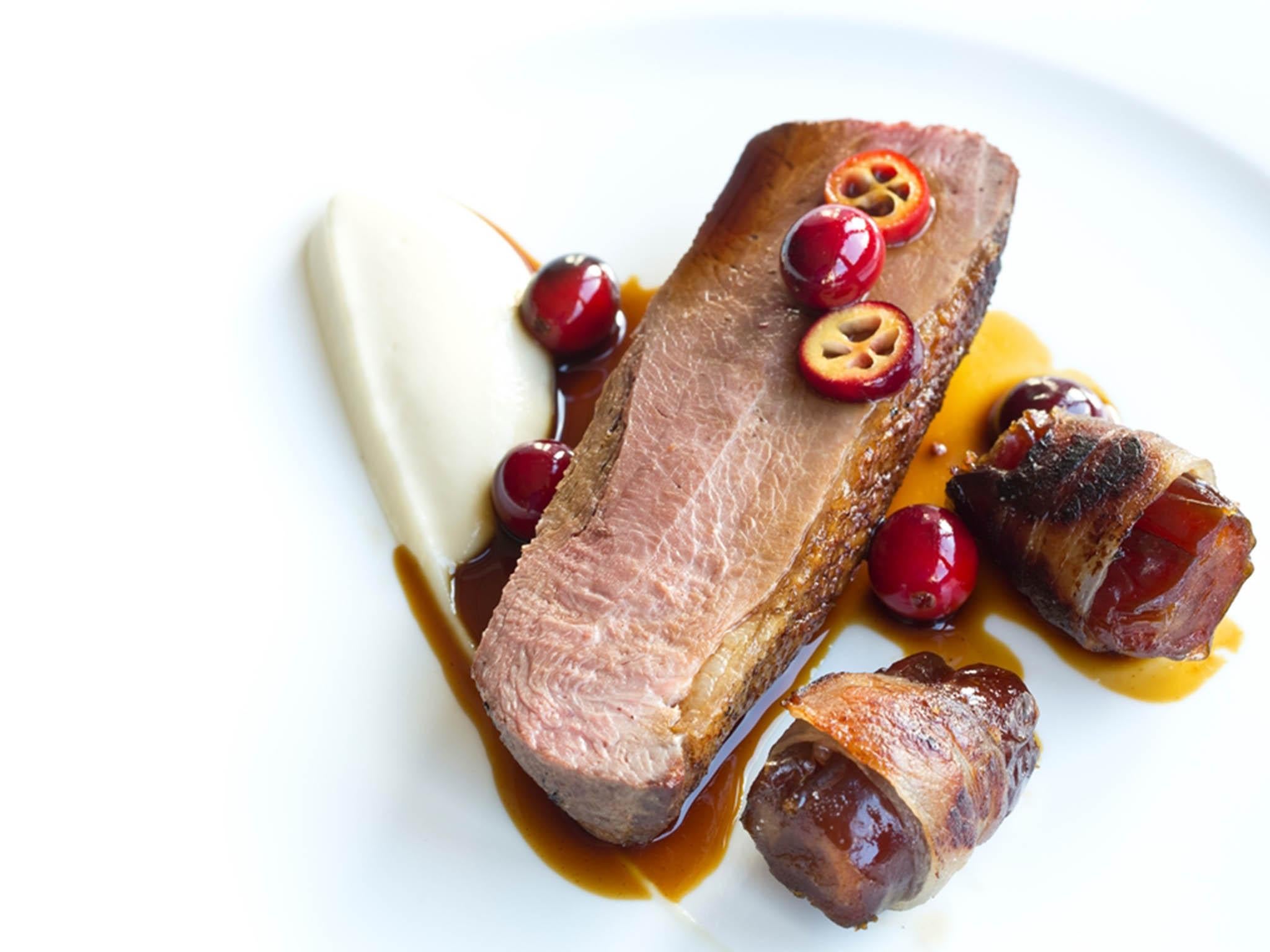 Bacon-wrapped dates flank the goose on a bed of celeriac purée