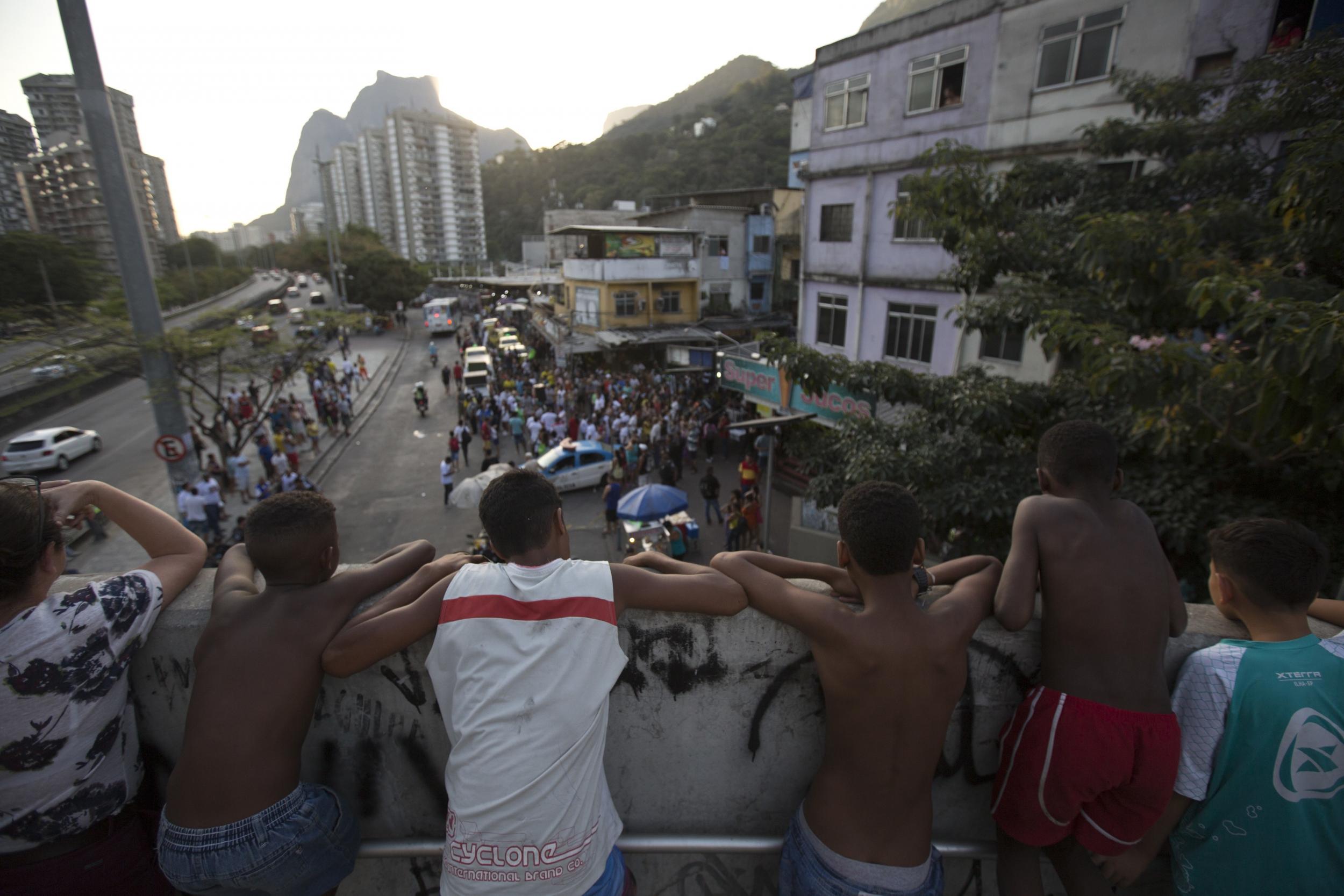 Youths watch a protest against police violence in the Rocinha favela, Rio de Janeiro