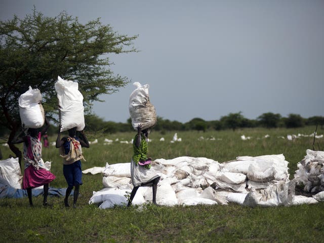 Women carry sacks of food, airdropped by the World Food Programme in South Sudan