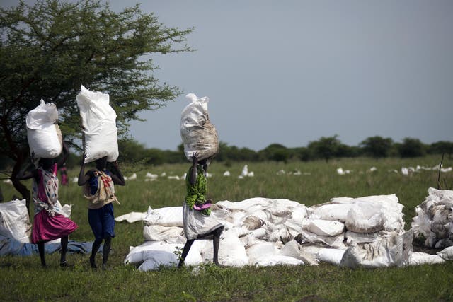 Women carry sacks of food, airdropped by the World Food Programme in South Sudan