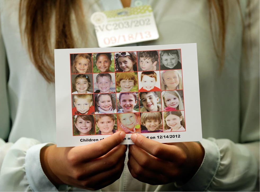 Kyra Murray holds a photo with victims of the shooting at Sandy Hook Elementary School during a press conference at the US Capitol 18 September 2013 in Washington, DC.