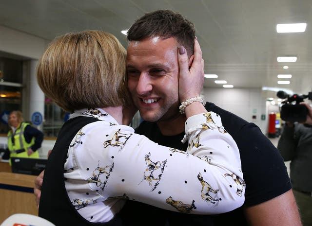 Jamie Harron is greeted by his mother Patricia after arriving home at Glasgow Airport