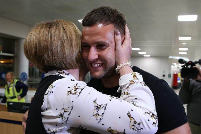 Jamie Harron is greeted by his mother Patricia after arriving home at Glasgow Airport