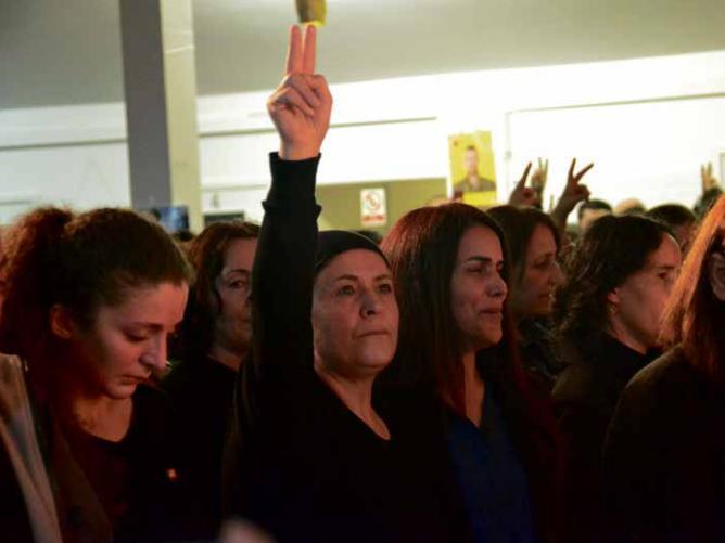 Mehmet's mother (centre) makes the peace symbol, which represents the Kurdish struggle for freedom, with his sister Gonca to her left