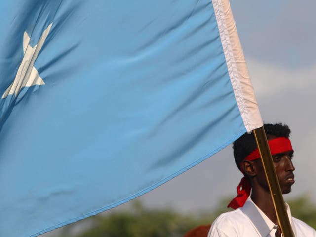 A protester carries the Somali national flag during a demonstration against the al-Shabaab militant group