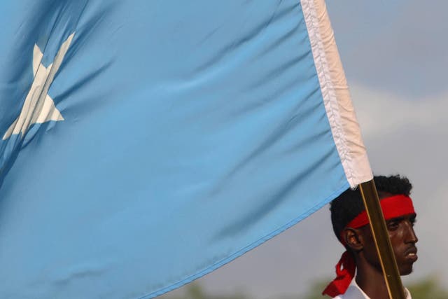 A protester carries the Somali national flag during a demonstration against the al-Shabaab militant group