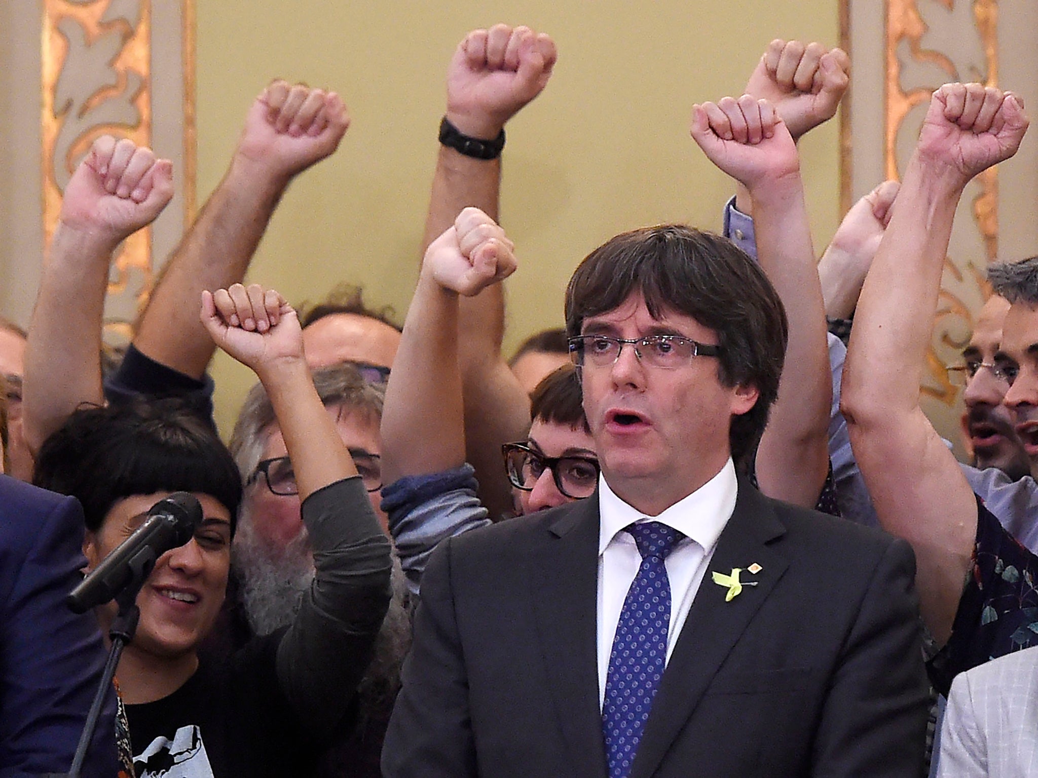 Catalan president Carles Puigdemont sings the Catalan anthem after parliamentary session last week