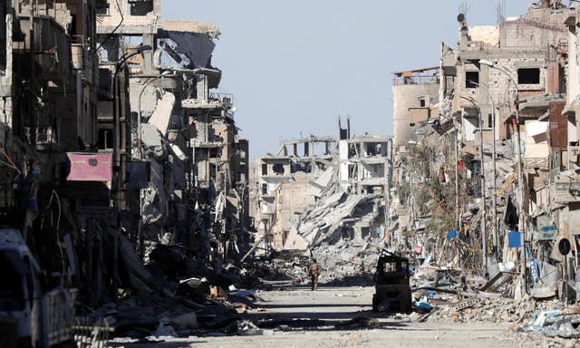 A Syrian Democratic Forces fighter stands amid the rubble of Clock Square in Raqqa, Syria on 18 October 2017