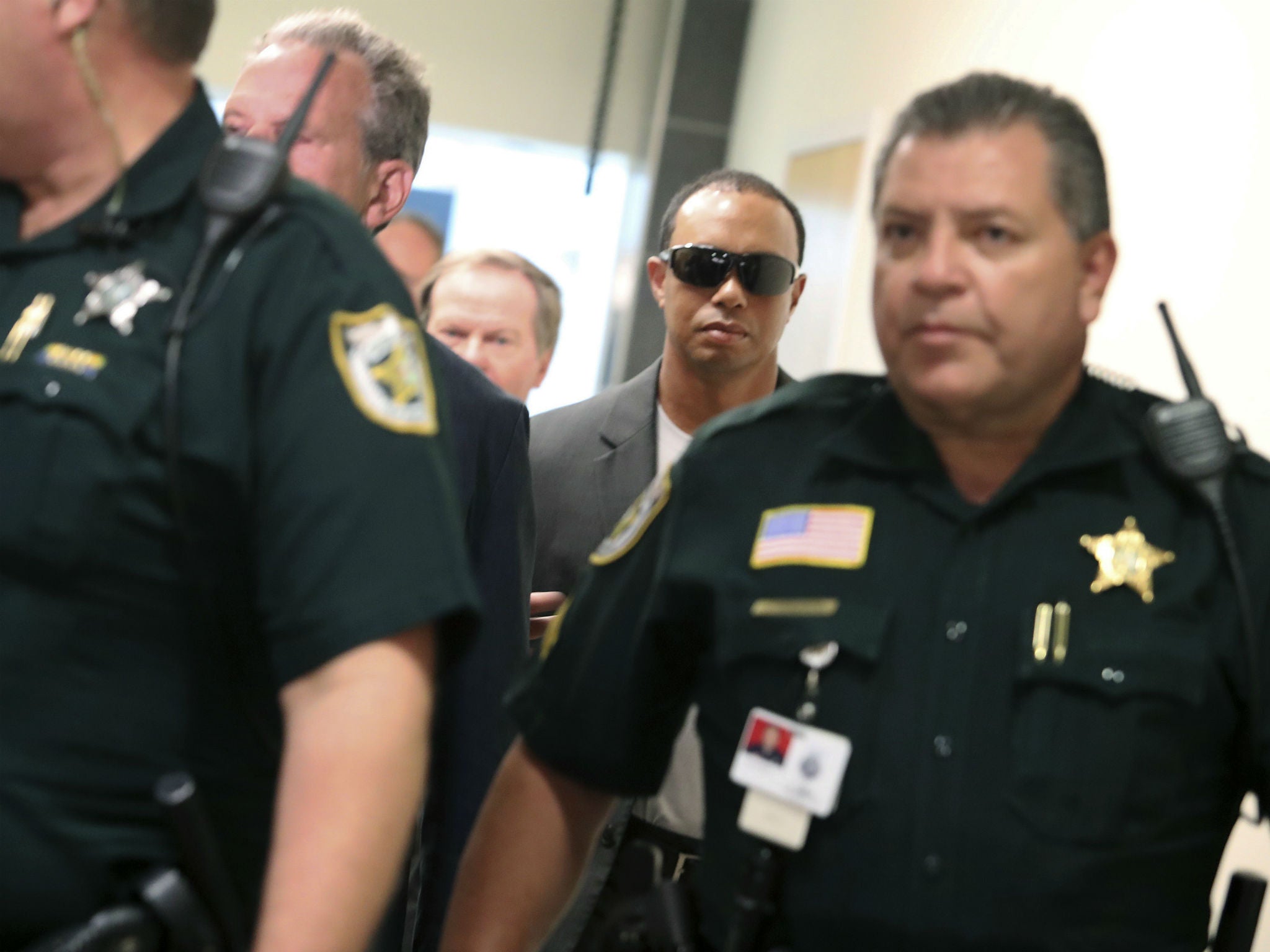 Tiger Woods, center, makes his way into a North County Courthouse courtroom in Palm Beach Gardens, Florida on Friday Oct. 27, 2017, to plead guilty to a second-degree misdemeanor reckless driving charge.