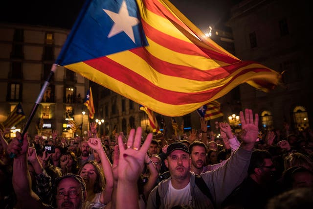 Pro-independence supporters cheer and wave "estelada" or pro independence flags in the square outside the Palau Generalitat in Barcelona