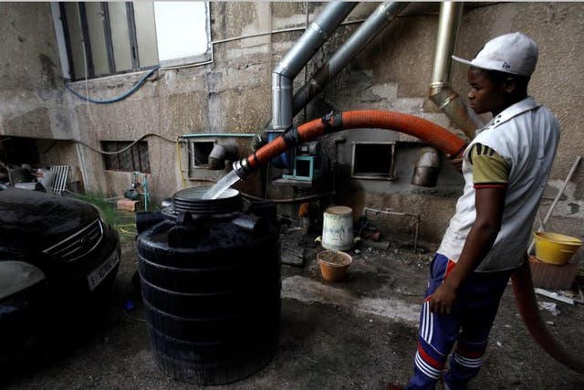 A man fills a tank with water in Tripoli, Libya