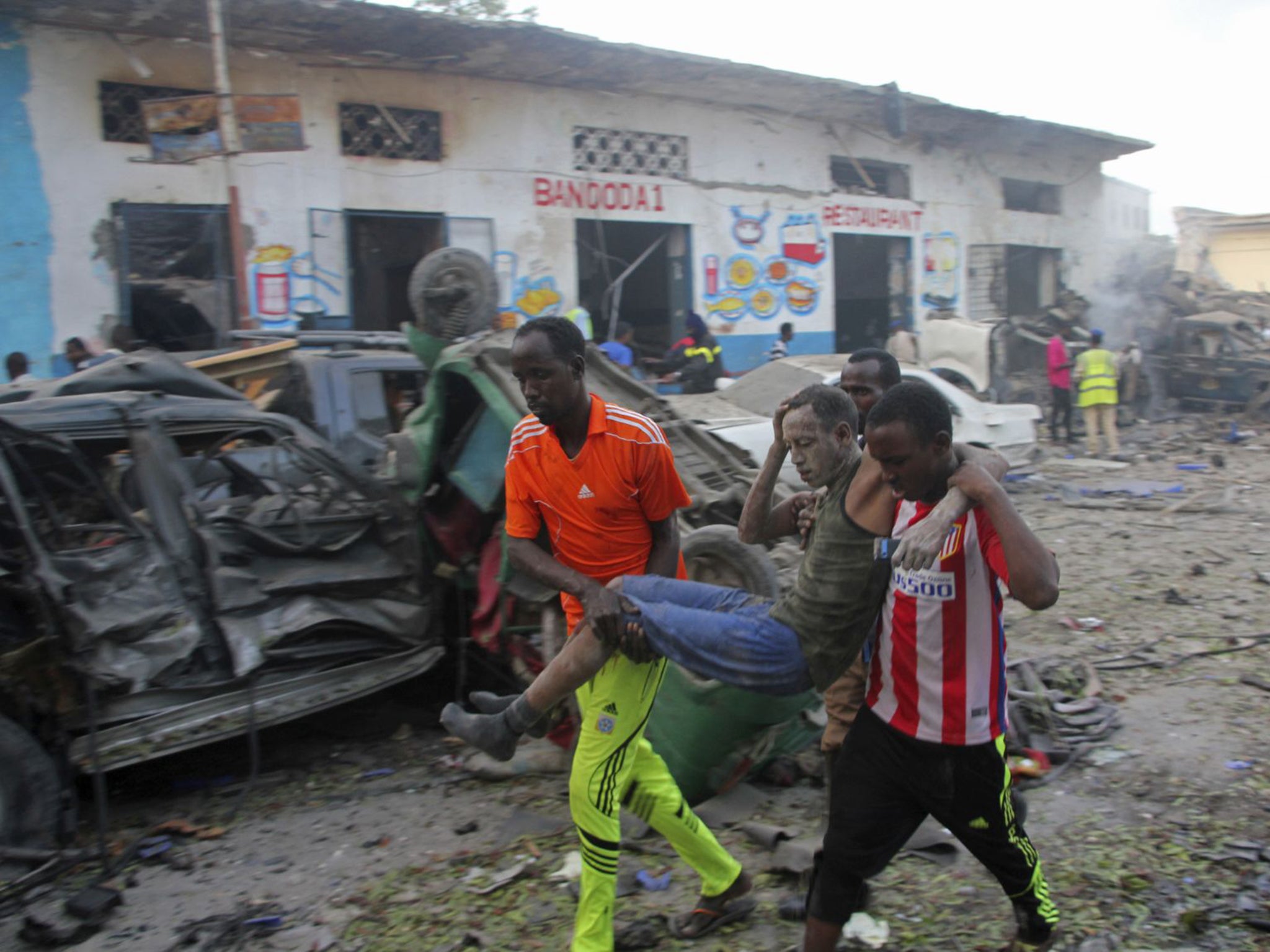 Somalis carry away a man injured after the car bomb attack