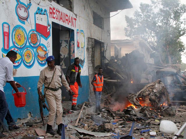 Somali security officers secure the scene of a suicide car bomb explosion, at the gate of Naso-Hablod Hotel in Hamarweyne district of Mogadishu, Somalia