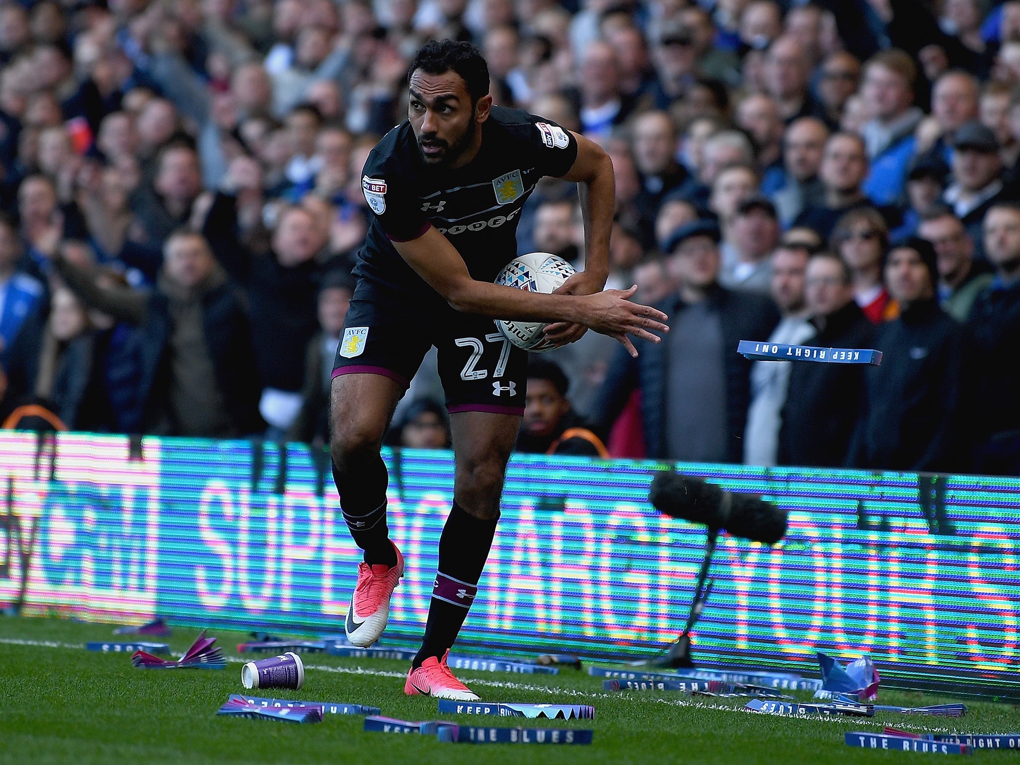 Ahmed Elmohamady attempts to remove clappers thrown onto the pitch by fans