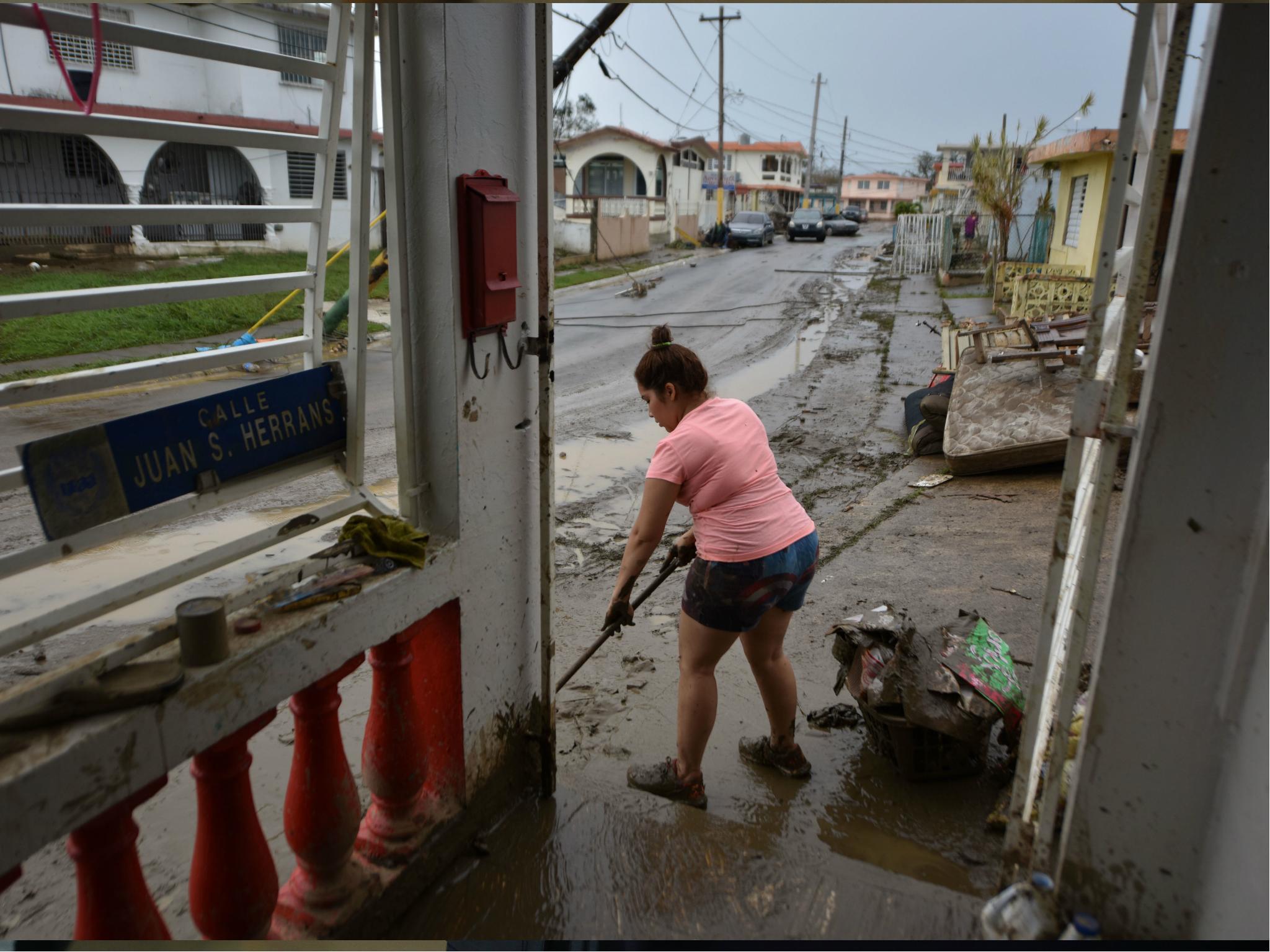 A woman removes mud from her damaged house in Toa Baja, 35 km from San Juan, Puerto Rico, on 23 September 2017.