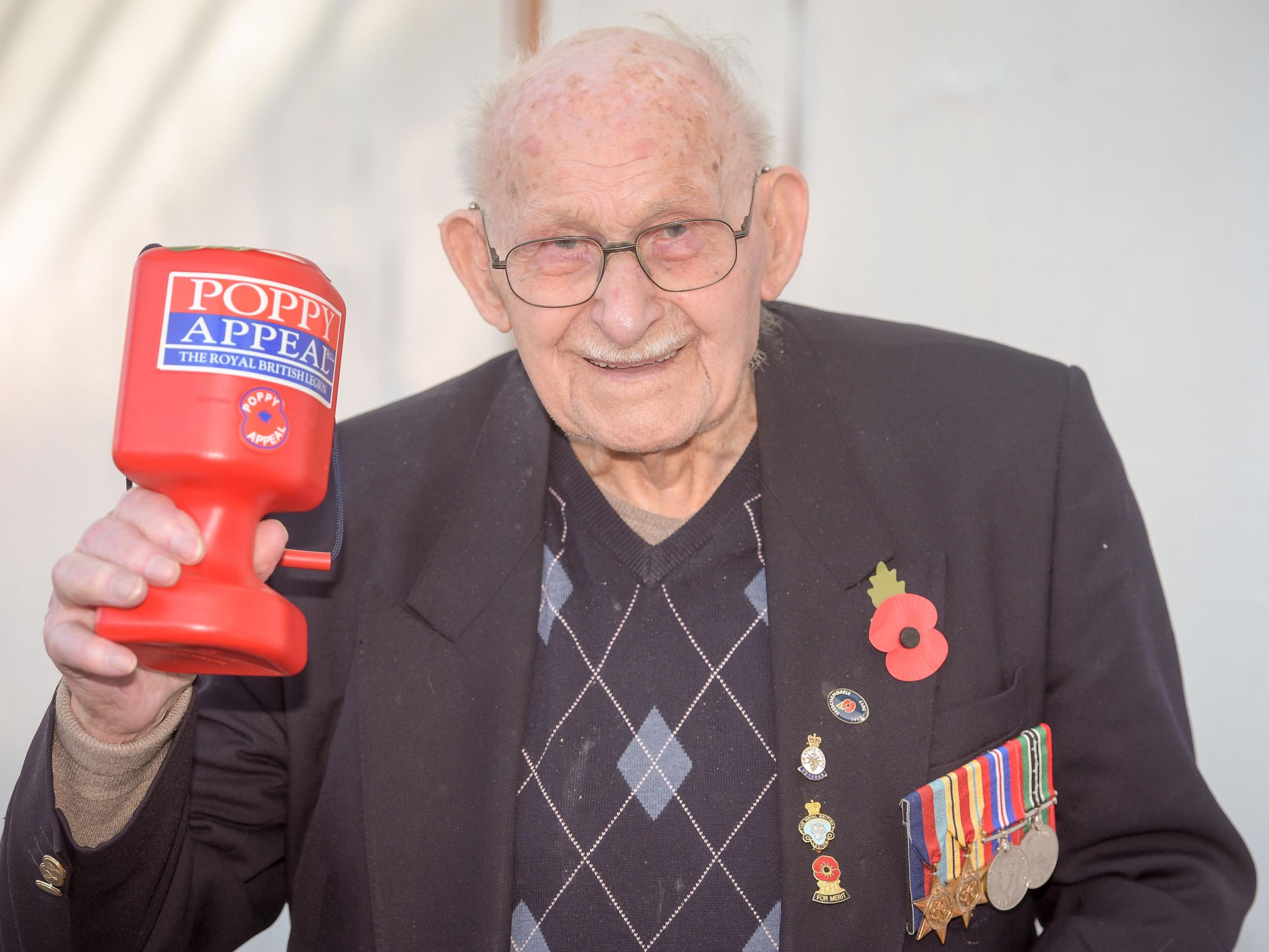 Poppy seller Ron Jones, who is 100 years old, holds his collection box outside a Tesco supermarket in Newport
