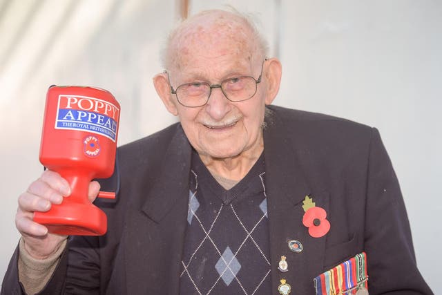 Poppy seller Ron Jones, who is 100 years old, holds his collection box outside a Tesco supermarket in Newport