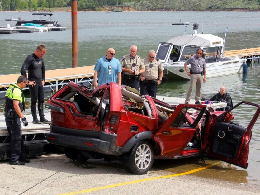 The Ada County dive team stands by the wreckage of an SUV driven by a 40-year-old Boise, Idaho, woman that plunged off a cliff into the Lucky Peak Reservoir in Boise in June 2016