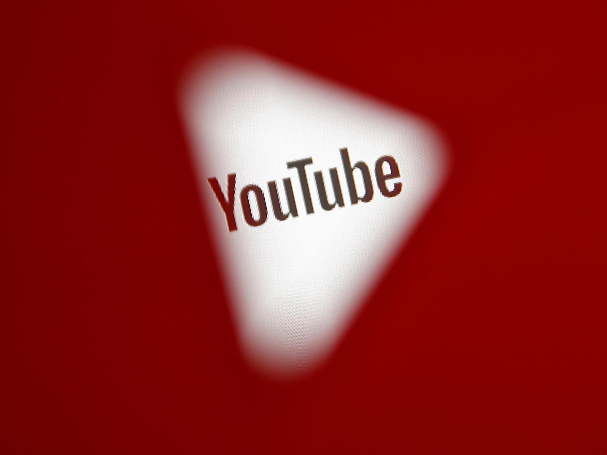 A 3D-printed YouTube icon is seen in front of a displayed YouTube logo in this illustration taken October 25, 2017