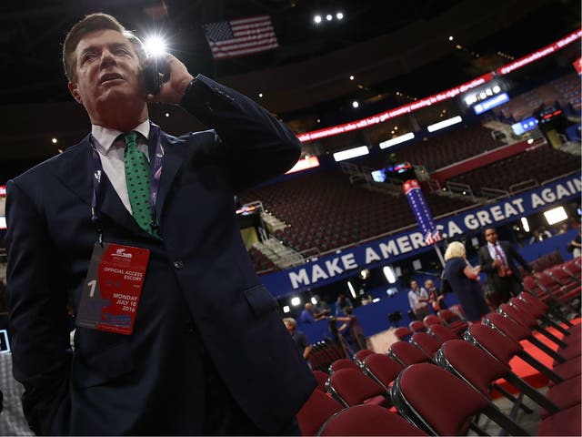 Paul Manafort, former campaign manager for President Donald Trump, speaks on the phone while touring the floor of the Republican National Convention 17 July 2016 in Cleveland, Ohio.
