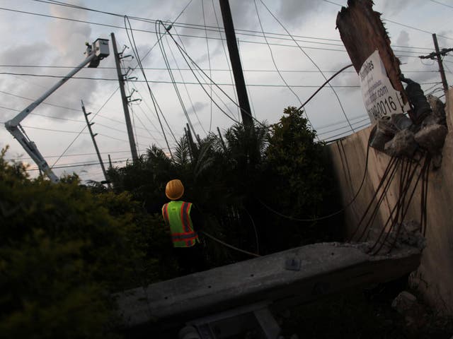 Workers of Puerto Rico's Electric Power Authority (PREPA) repair part of the electrical grid in Manati after Hurricane Maria hit the area in September