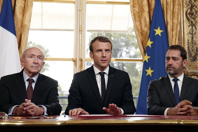French President Emmanuel Macron (C) addresses the press flanked by French Interior Minister Gerard Collomb (L) and French Prime Minister Edouard Philippe (R) after he signed a counterterrorism law at the Elysee Palace in Paris, France