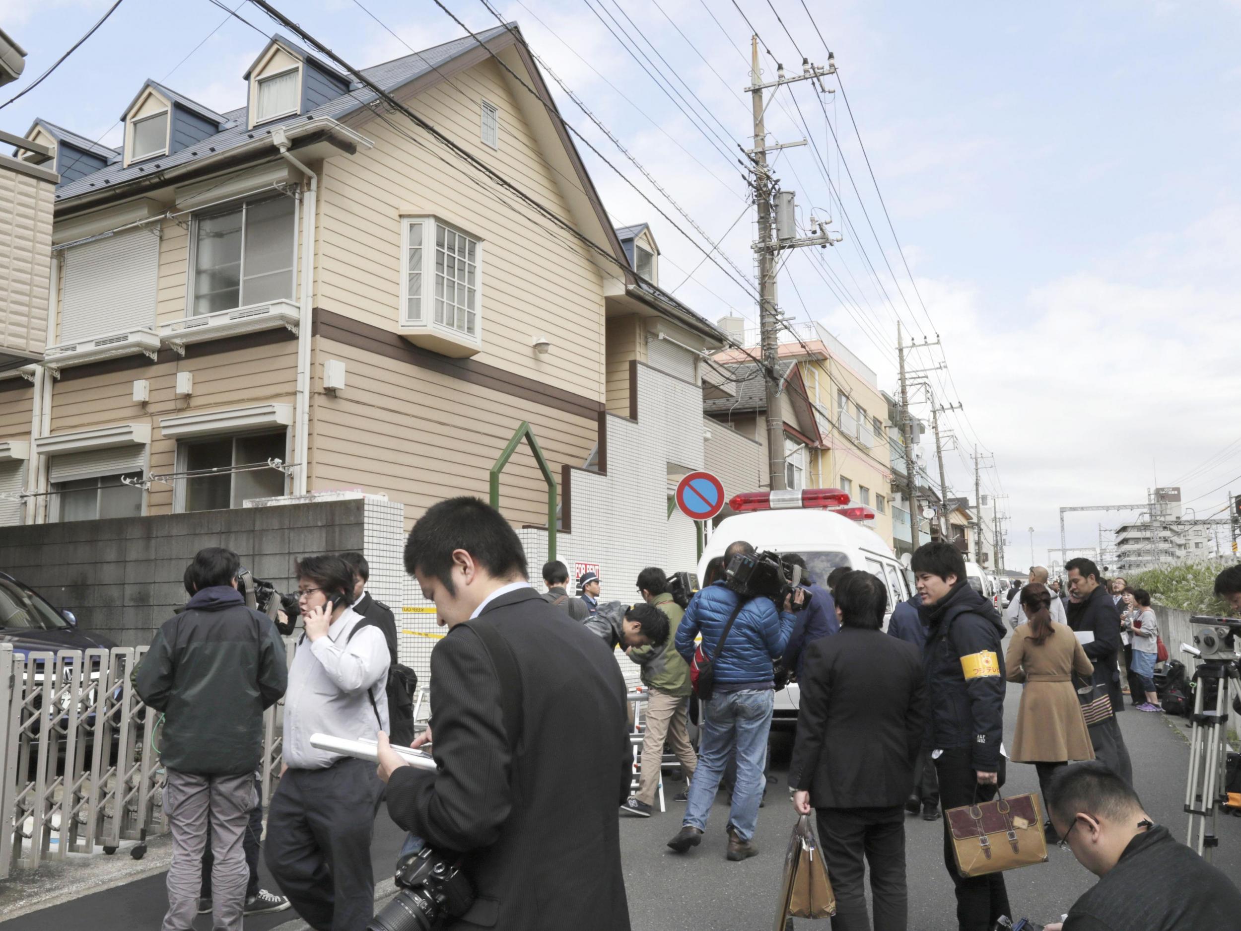 People gather in front of the apartment where police found dismembered bodies in coolers in Zama city, south west of Tokyo