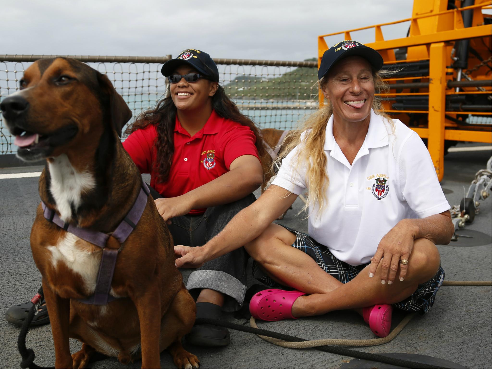 Jennifer Appel, right, and Tasha Fuiava sit with their dogs on the deck of the USS Ashland Monday, 30 October 2017 in Okinawa, Japan.