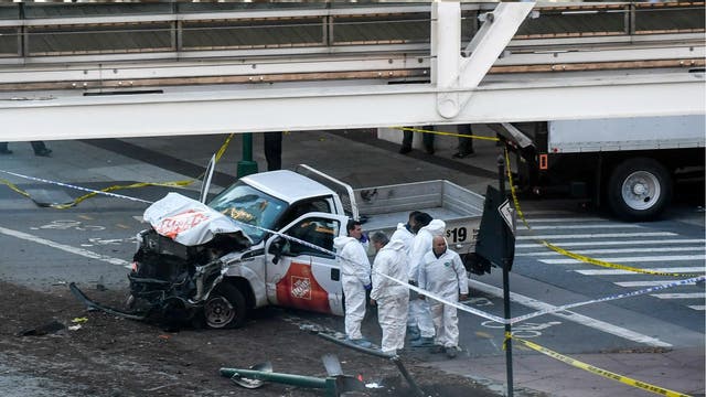 Investigators inspect a truck following a shooting incident in New York on 31 October 2017. Several people were killed and numerous others injured in New York on Tuesday when a suspect plowed a vehicle into a bike and pedestrian path in Lower Manhattan, and struck another vehicle on Halloween, police said. A suspect exited the vehicle holding up fake guns, before being shot by police and taken into custody, officers said. The motive was not immediately apparent.
