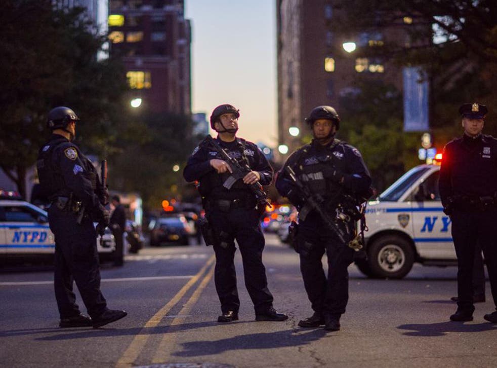 Heavily armed police stand guard near the scene after a motorist drove onto a busy bicycle path near the World Trade Center memorial and struck several people
