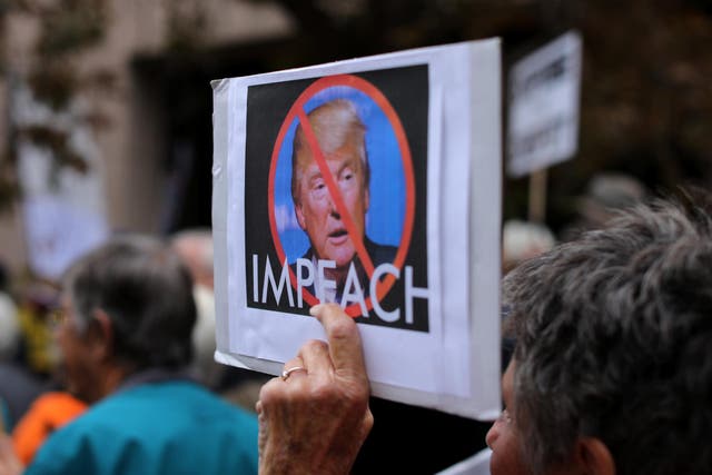 Demonstrators protest against US President Donald Trump outside Republican congressman Darrell Issa's office in Vista, California