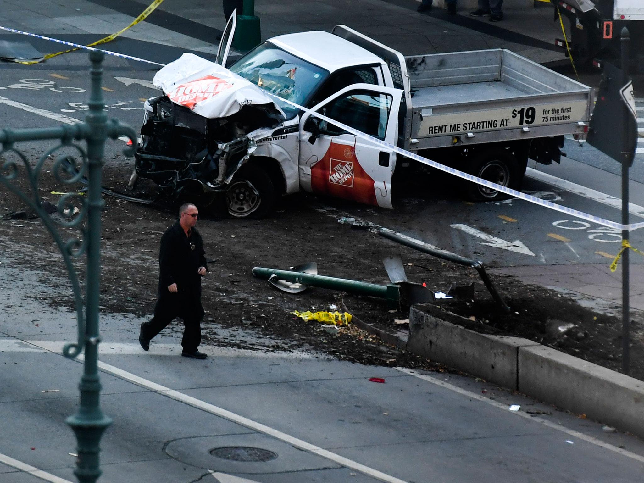 An investigator walks past the crashed pickup truck following the attack