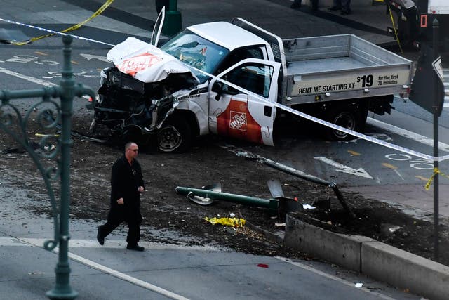 An investigator walks past the crashed pickup truck following the attack