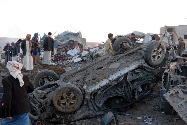 People gather at the site of an airstrike in the north western city of Saada, Yemen