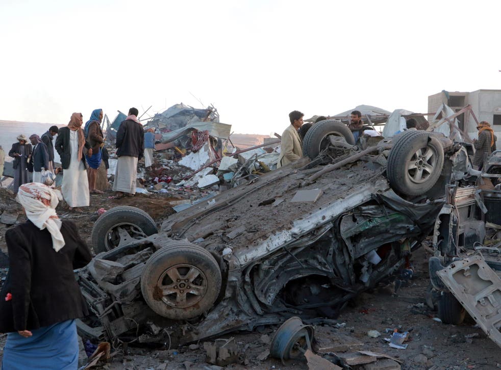 People gather at the site of an airstrike in the north western city of Saada, Yemen