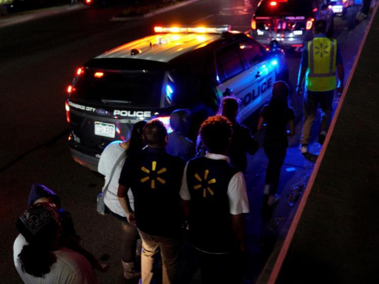 Walmart employees and shoppers leave the scene of a shooting at a Walmart in Thornton, Colorado