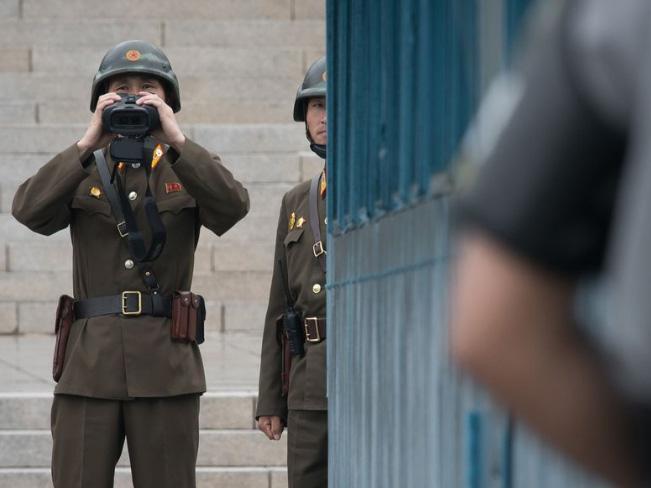 A North Korean soldier holds binoculars before the military demarcation line separating North and South Korea at the truce village of Panmunjom