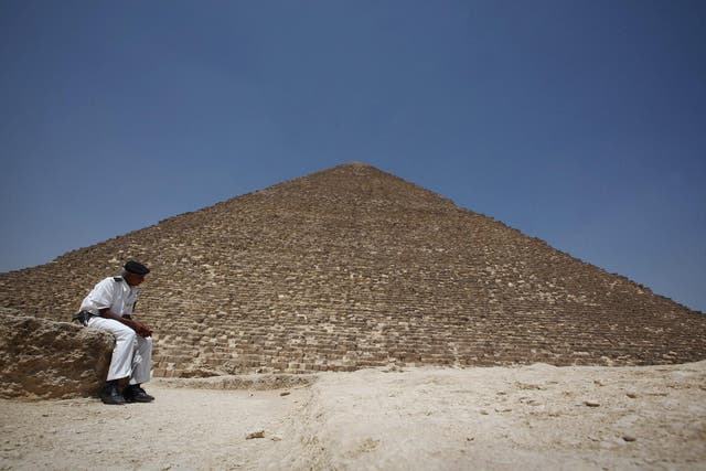A tourist policeman sits under the great Pyramid of Cheops on May 28, 2011 in Giza, Egypt
