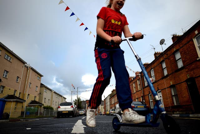 A girl rides her scooter in the walled-off loyalist Protestant enclave called The Fountain, situated within the city of Derry