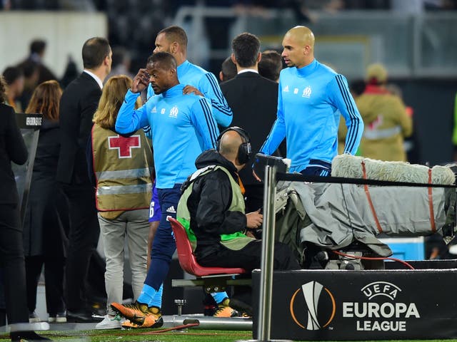 Patrice Evra is escorted from the pitch by his own teammates after being sent off