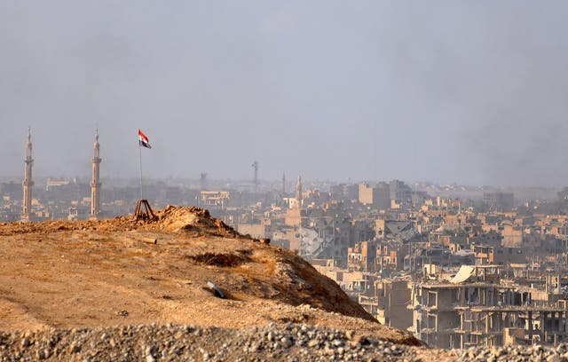 A Syrian flag flies over Deir Ezzor as government forces fight Isis militants on 2 November