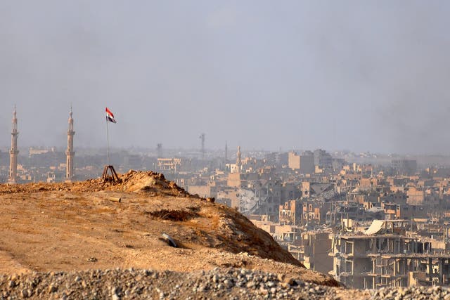 A Syrian flag flies over Deir Ezzor as government forces fight Isis militants on 2 November