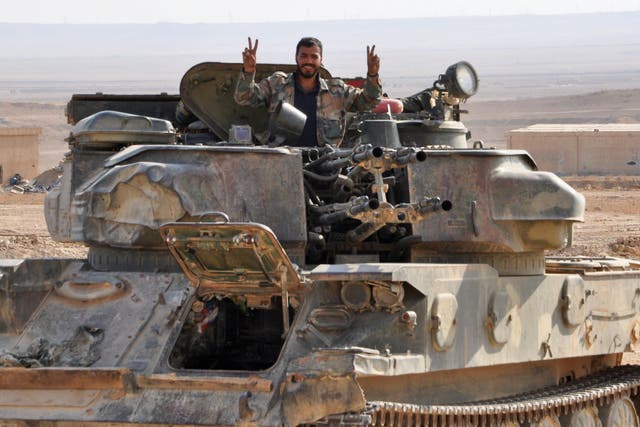 A Syrian soldier flashes a ‘V for Victory’ sign from his tank