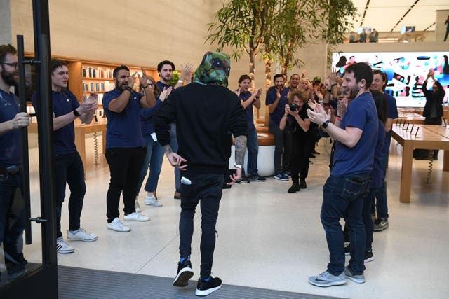 Marco White Jr., son of British chef Marco Pierre White, is applauded by staff as he is the first customer to enter Apple's Regent Street store in central London on November 3, 2017