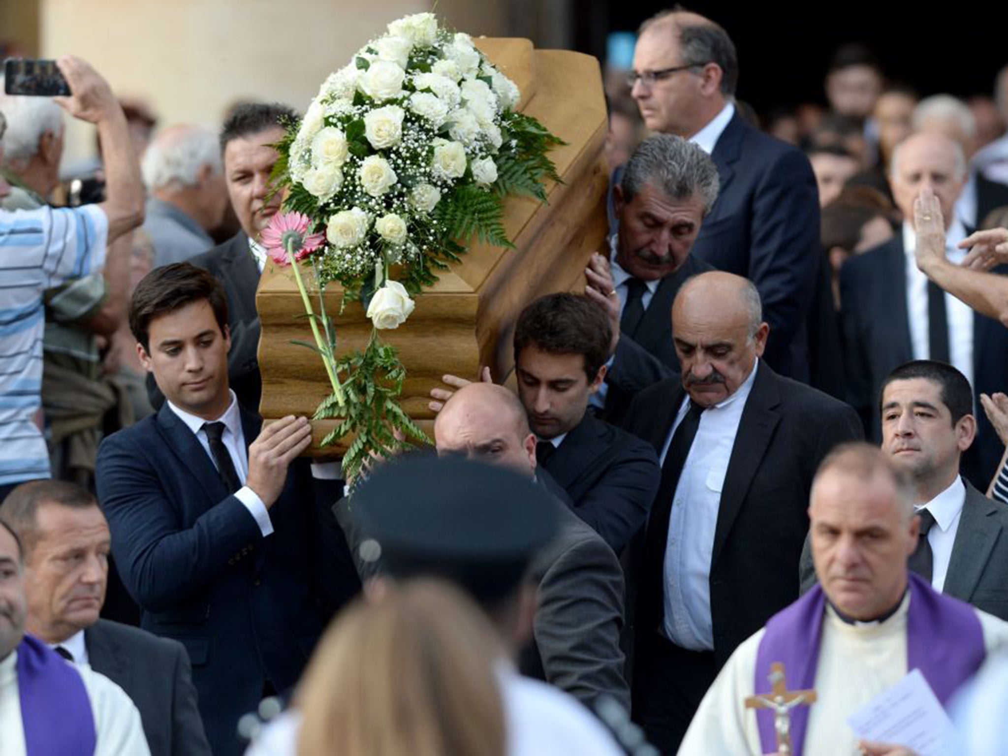 The sons of murdered journalist carry their mother’s coffin out of the church in Mosta