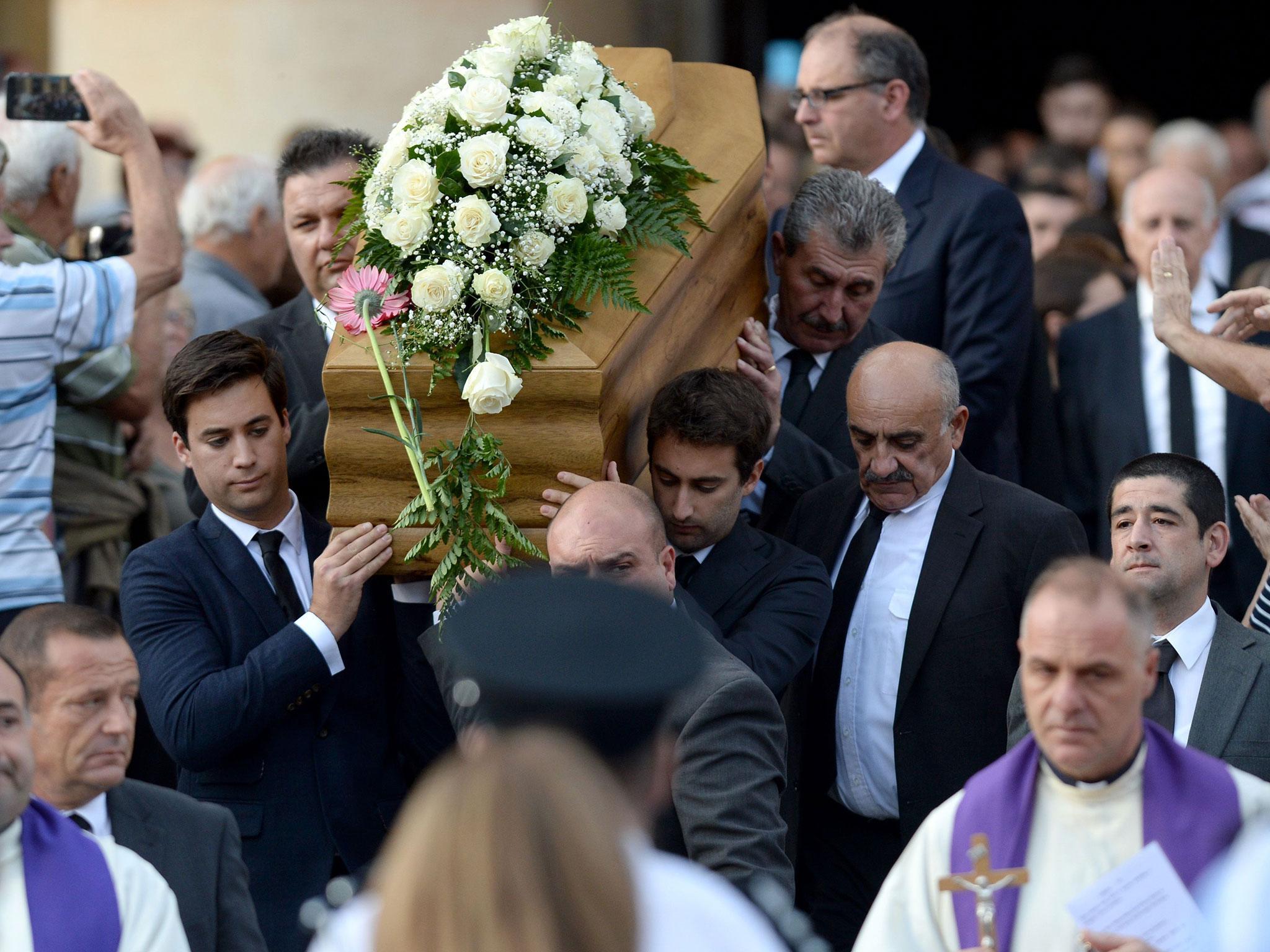 The sons of murdered journalist Daphne Caruana Galizia carry their mother’s coffin from the church in Mosta
