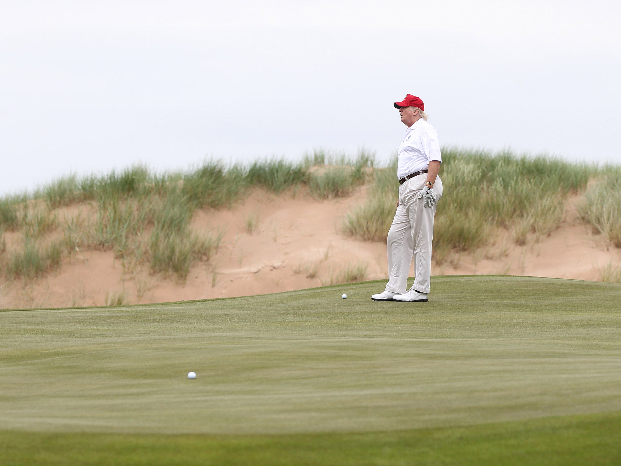 Donald Trump playing at his golf course at its grand opening in 2012